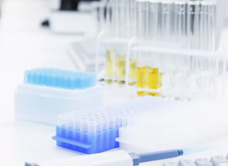 研究室でフラスコを使い成分を確認する研究員