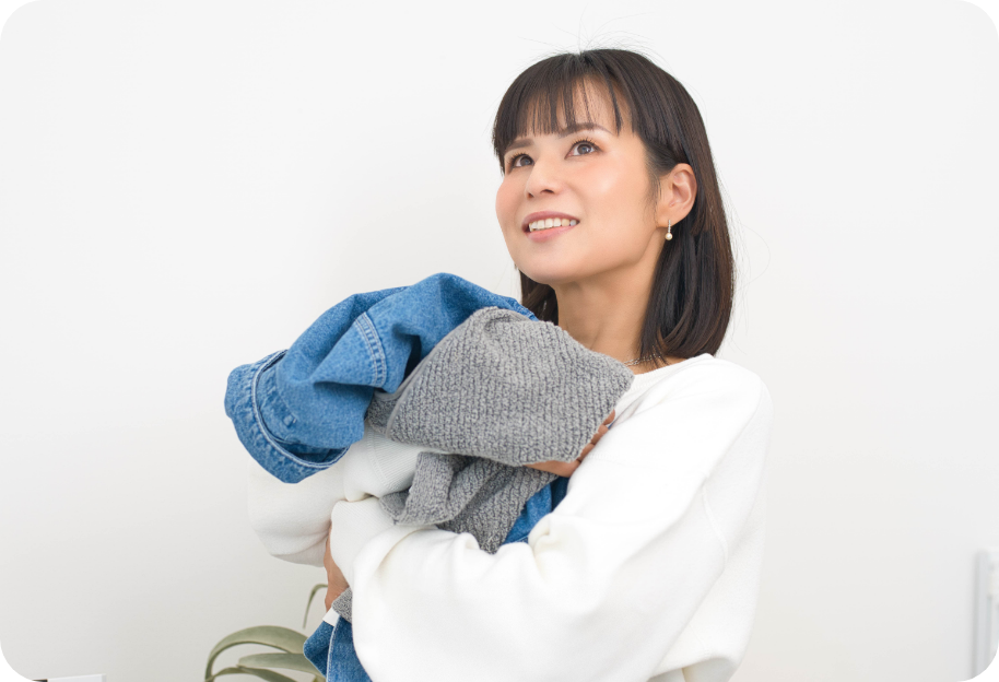 洗濯物を干しながら笑顔で確認する女性