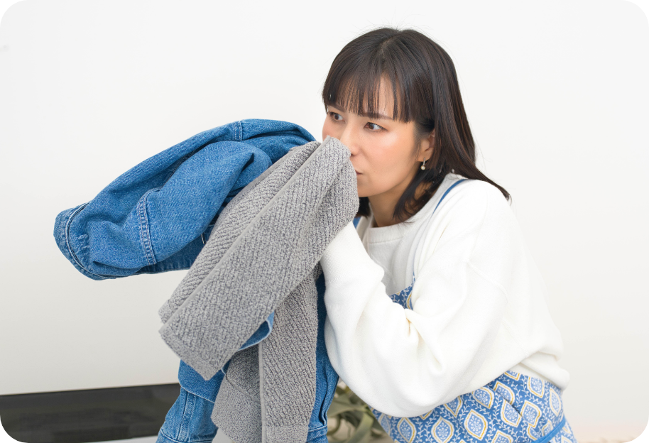 洗濯物を干しながら笑顔で確認する女性