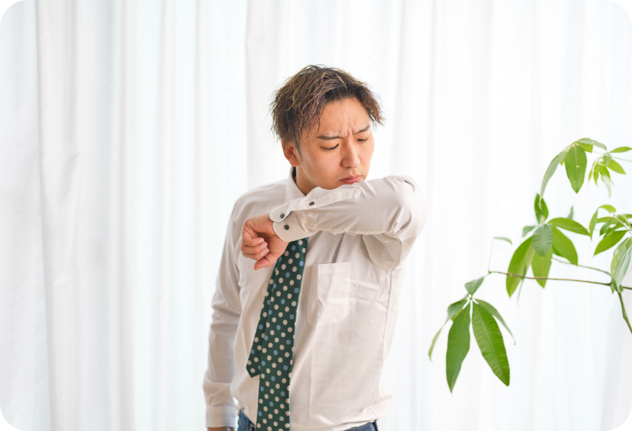 シャツの胸元を確認する男性の上半身